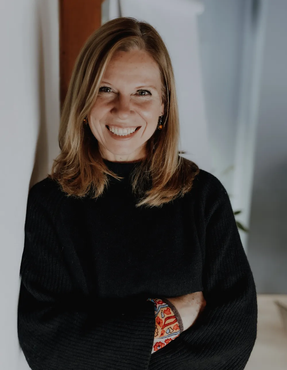 Ulrike Funke lehnt an einer Wand und schaut in die Kamera.